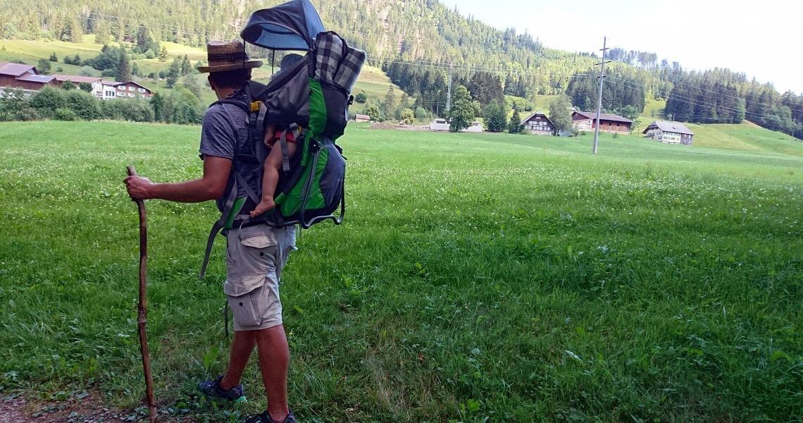 Vater mit Kind im Kindertragerucksack während einer Wanderung